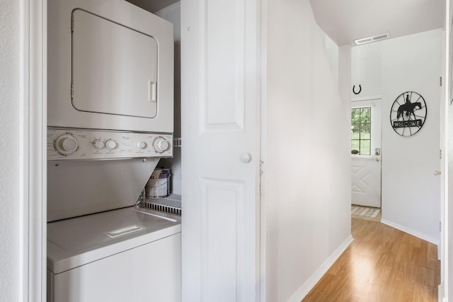 washroom featuring light wood-type flooring and stacked washing maching and dryer