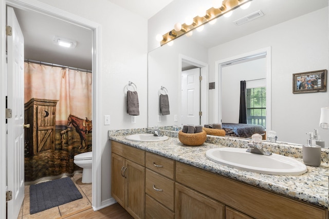 bathroom with vanity, toilet, and tile patterned floors