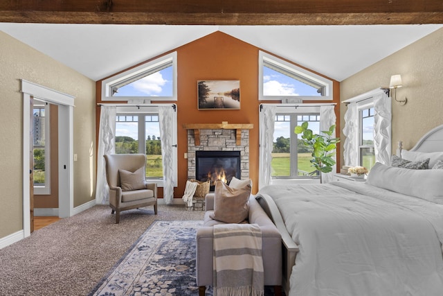 bedroom featuring vaulted ceiling with beams, carpet floors, and a stone fireplace