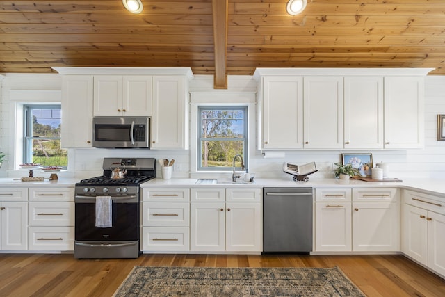 kitchen featuring wooden ceiling, white cabinets, appliances with stainless steel finishes, and light wood-type flooring