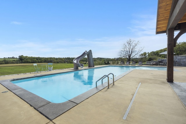 view of pool with a water slide and a patio area