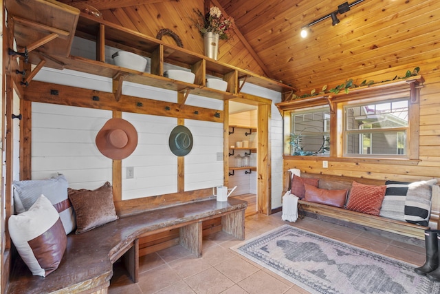 interior space with high vaulted ceiling, wooden walls, rail lighting, wood ceiling, and light tile patterned flooring