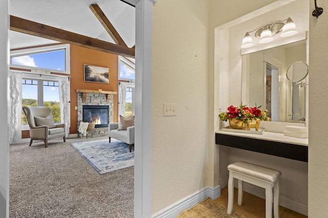 bathroom with a fireplace, high vaulted ceiling, and beam ceiling