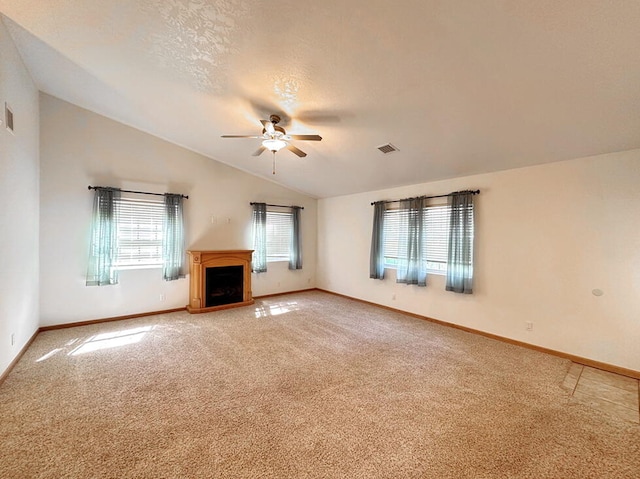 unfurnished living room featuring lofted ceiling, ceiling fan, carpet, and a textured ceiling