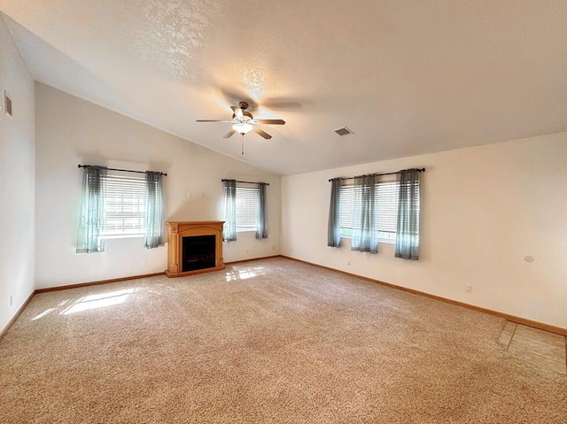 unfurnished living room with vaulted ceiling, ceiling fan, light carpet, a fireplace, and baseboards