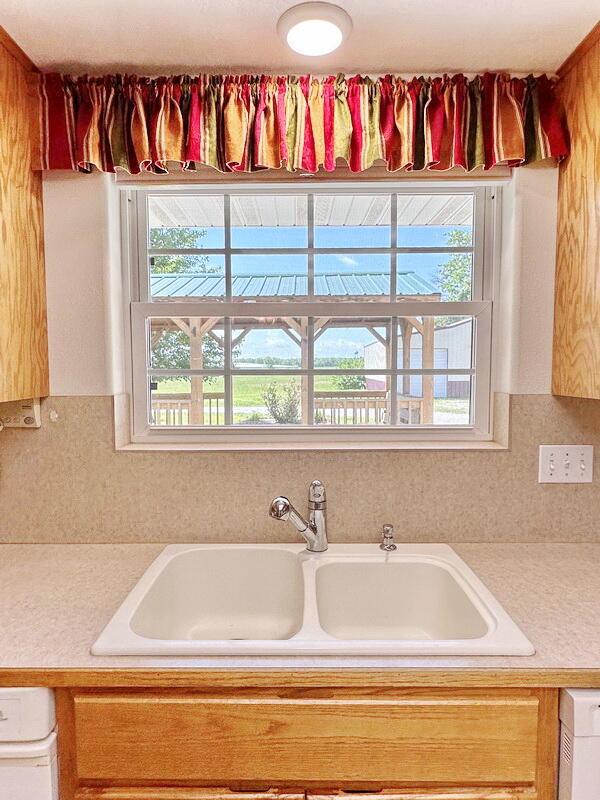 kitchen with light countertops, tasteful backsplash, and a sink