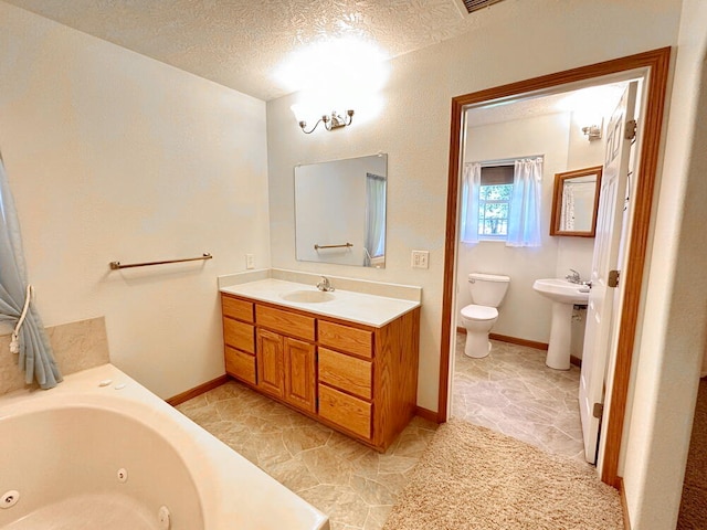 bathroom with a bathtub, vanity, a textured ceiling, and toilet