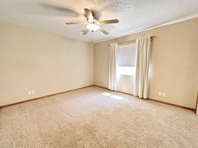 unfurnished room featuring light carpet, a ceiling fan, and baseboards