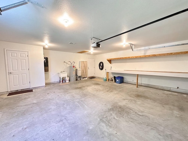 garage with a garage door opener and electric water heater