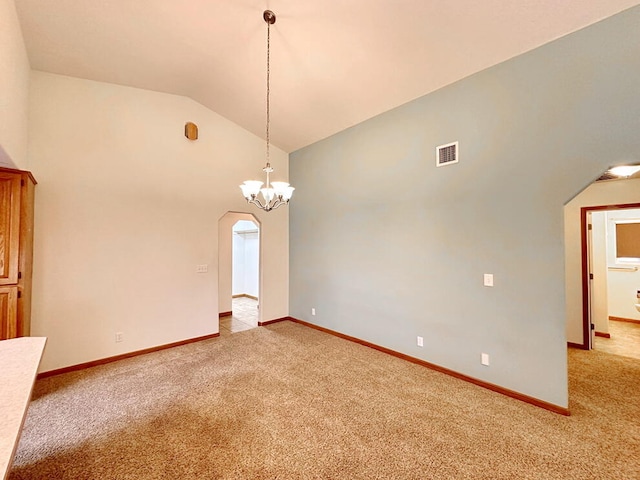 carpeted spare room featuring an inviting chandelier and high vaulted ceiling