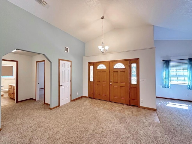 foyer entrance with light carpet, arched walkways, baseboards, high vaulted ceiling, and a notable chandelier