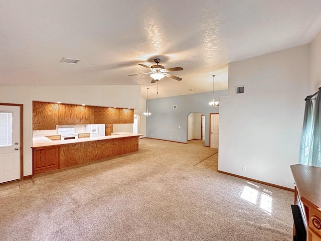 unfurnished living room featuring a textured ceiling, lofted ceiling, ceiling fan, and light colored carpet