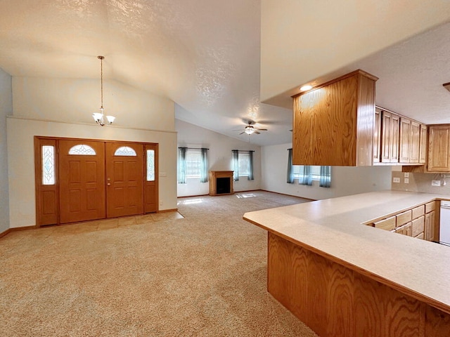 kitchen featuring pendant lighting, light colored carpet, lofted ceiling, and a healthy amount of sunlight