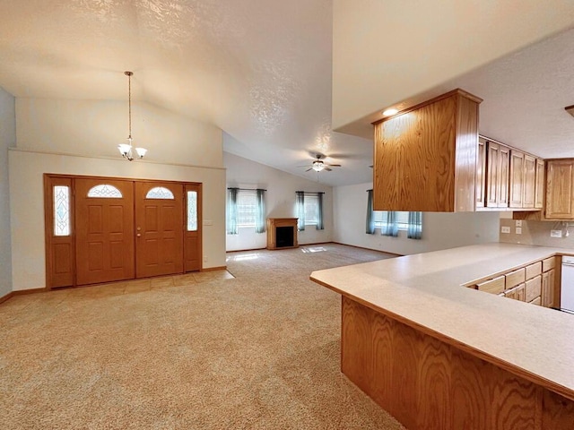 foyer featuring a textured ceiling, ceiling fan with notable chandelier, a fireplace, light colored carpet, and baseboards