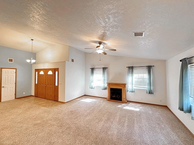 unfurnished living room featuring ceiling fan with notable chandelier, a textured ceiling, lofted ceiling, and carpet