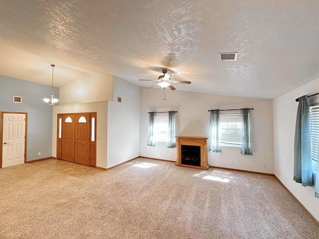 unfurnished living room featuring ceiling fan with notable chandelier, vaulted ceiling, a textured ceiling, and light colored carpet