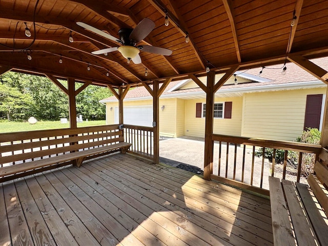 deck with a garage and ceiling fan