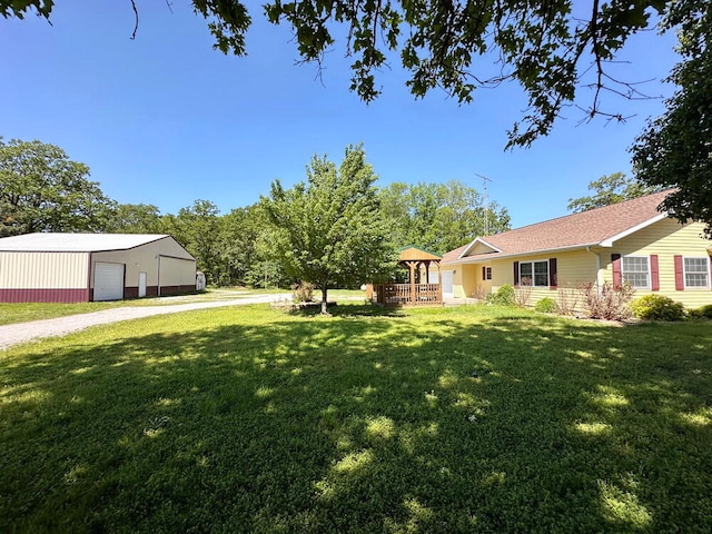 view of yard with a garage, a wooden deck, and an outdoor structure