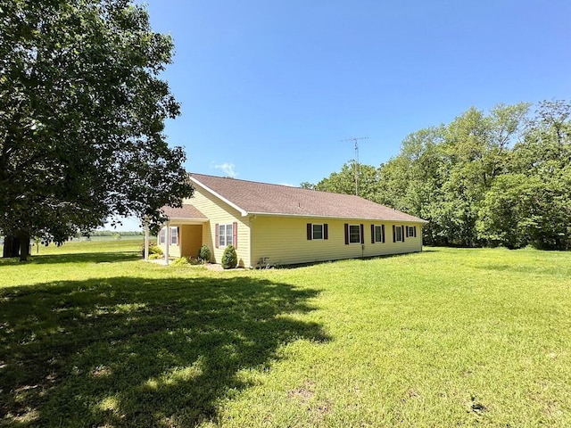 rear view of house featuring a yard