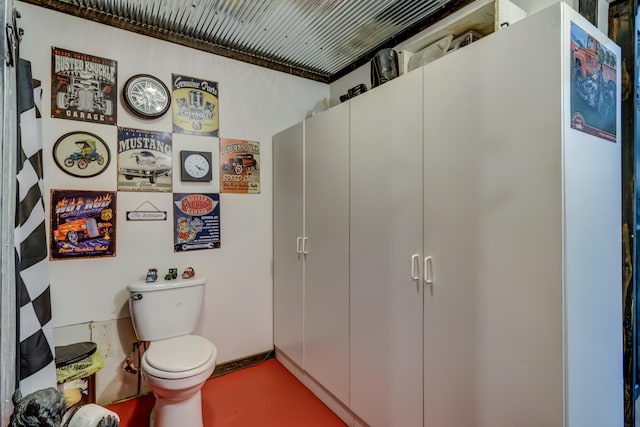 bathroom featuring concrete flooring and toilet