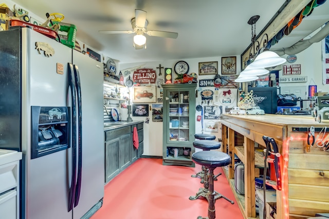 kitchen featuring pendant lighting, stainless steel fridge with ice dispenser, ceiling fan, and sink