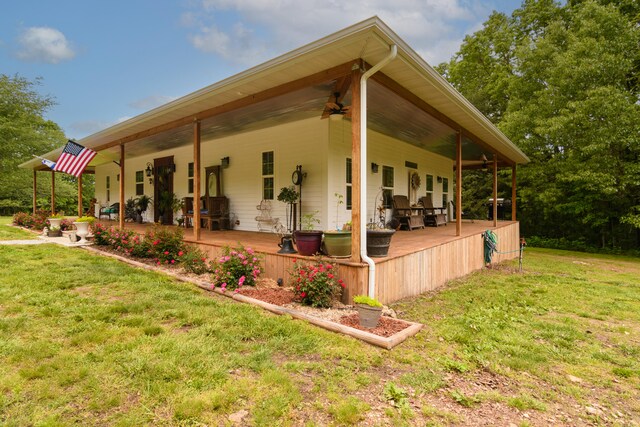 view of home's exterior featuring ceiling fan and a lawn