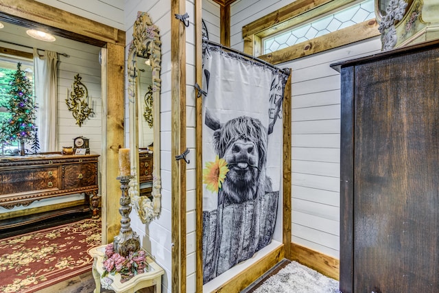 bathroom with hardwood / wood-style flooring and wood walls