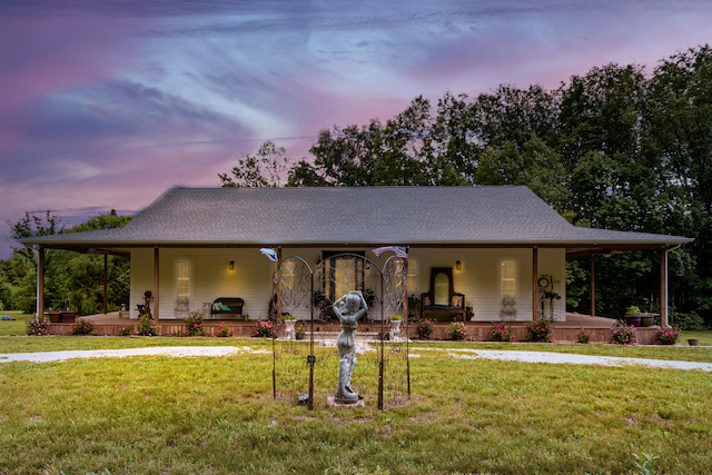 farmhouse-style home with covered porch and a lawn