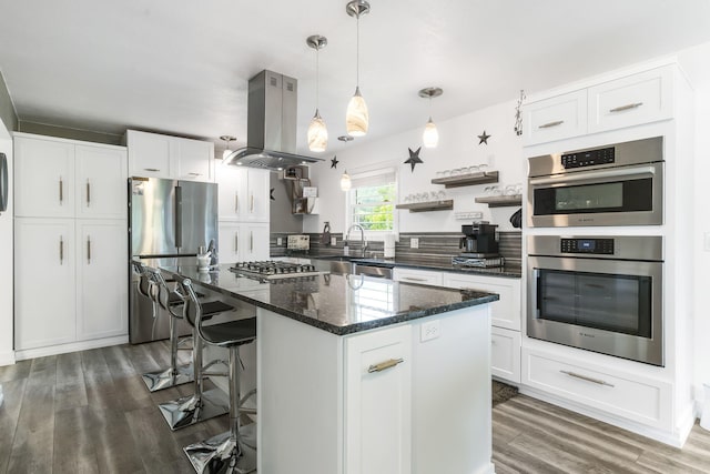 kitchen featuring island range hood, a kitchen island, white cabinetry, and appliances with stainless steel finishes