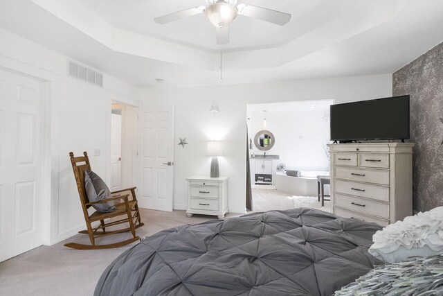 bedroom with a tray ceiling, ceiling fan, and light colored carpet