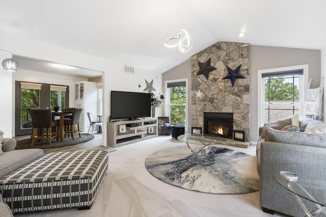 carpeted living room featuring a stone fireplace and vaulted ceiling