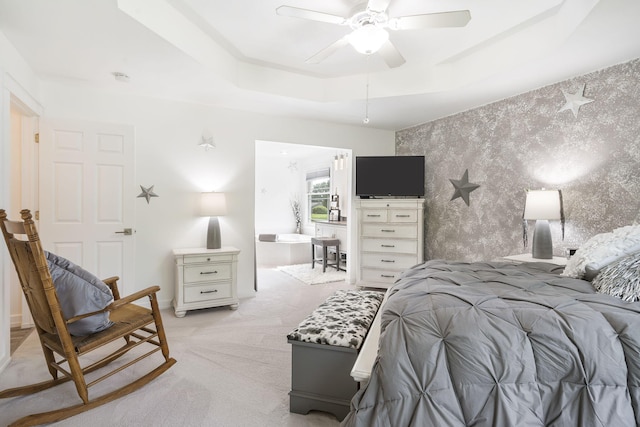 bedroom with light colored carpet, a raised ceiling, and ceiling fan