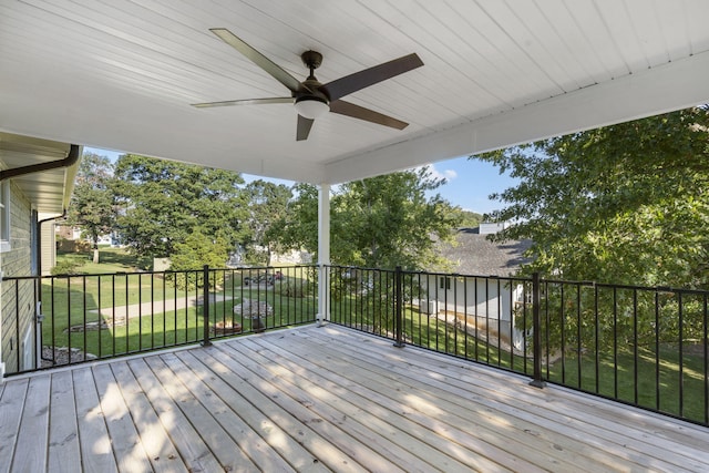 wooden deck with a lawn and ceiling fan