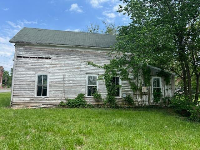 back of house featuring a lawn