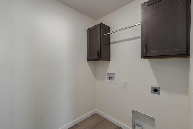 clothes washing area with cabinets, washer hookup, hardwood / wood-style flooring, and electric dryer hookup