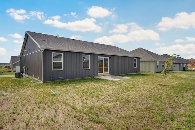 rear view of property with cooling unit, a lawn, and a patio