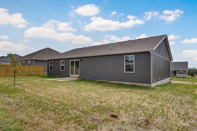 back of property with a lawn and a patio area