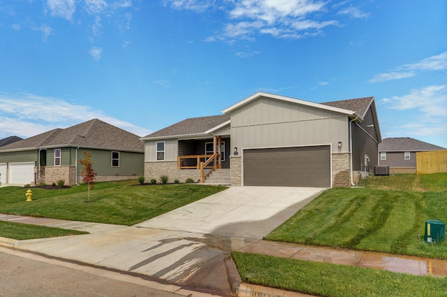 view of front of home featuring a garage, cooling unit, and a front yard