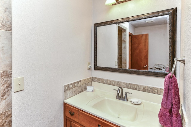 bathroom featuring a textured wall and vanity