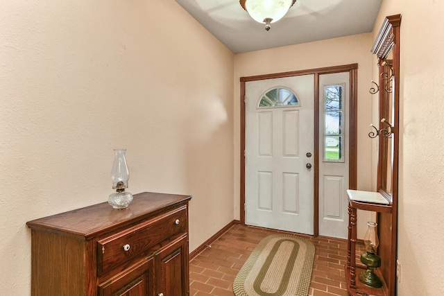 entrance foyer with brick floor and baseboards