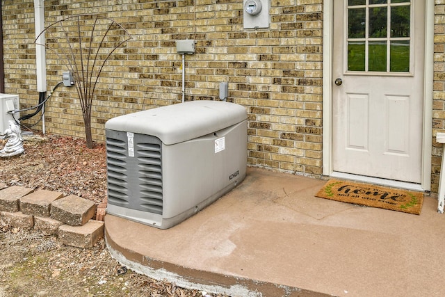 exterior details with brick siding, electric meter, and a power unit