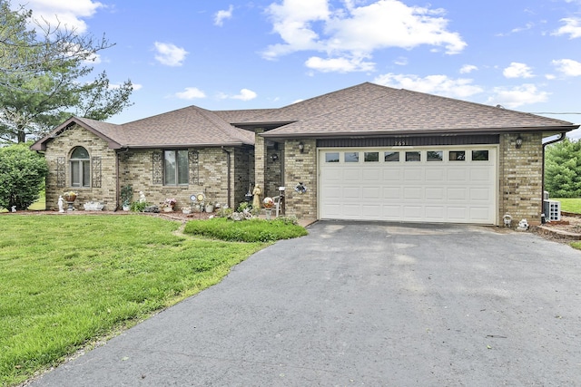 view of front of home with roof with shingles, a front lawn, driveway, brick siding, and an attached garage