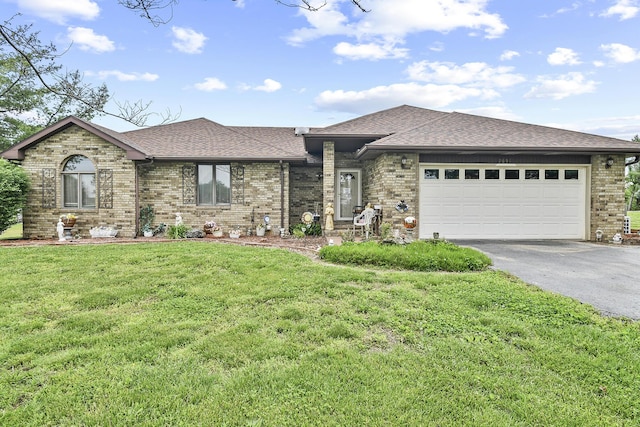 view of front facade with brick siding, a front lawn, aphalt driveway, and a shingled roof
