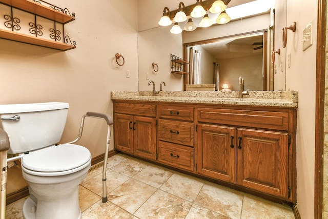 full bath featuring double vanity, toilet, baseboards, and a sink