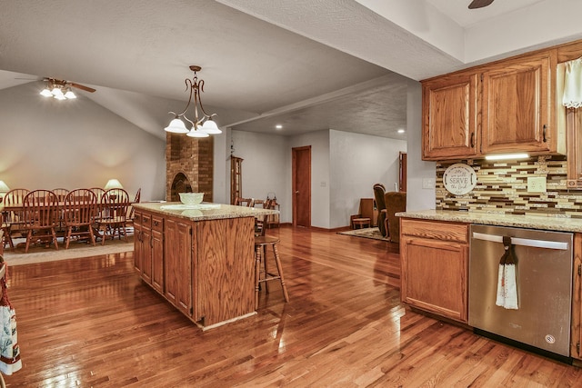 kitchen featuring dishwasher, wood finished floors, brown cabinets, and a ceiling fan