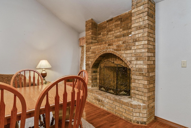 living area with lofted ceiling, wood finished floors, and a fireplace