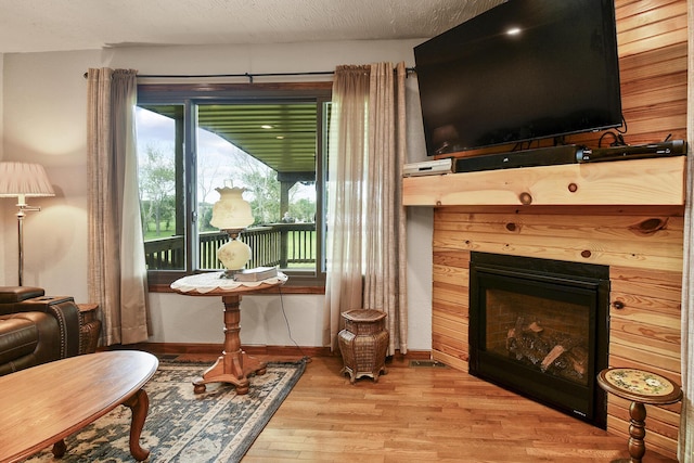 living area featuring light wood finished floors, baseboards, and a fireplace