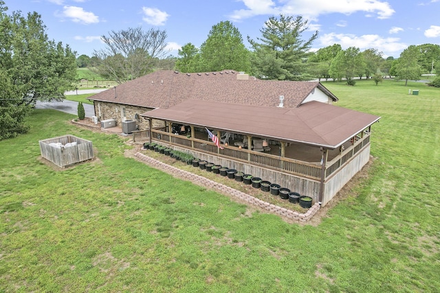 back of house featuring central air condition unit and a yard