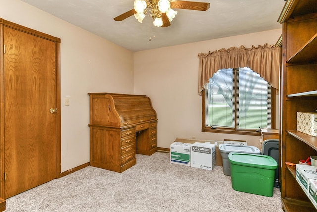 interior space with baseboards, a ceiling fan, and carpet
