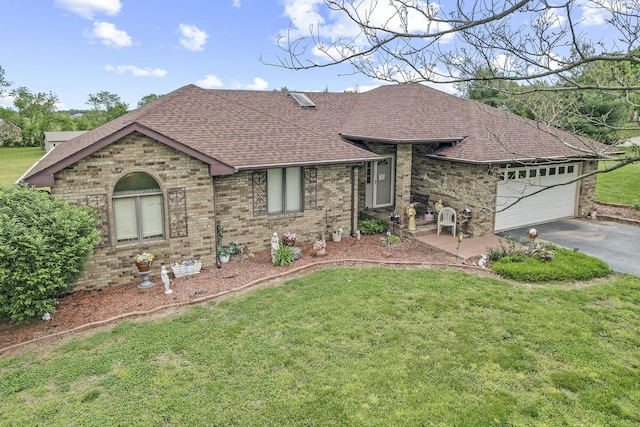 view of front facade with a front lawn, aphalt driveway, a shingled roof, an attached garage, and brick siding